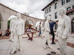 Student dancers among Street Crossing statues